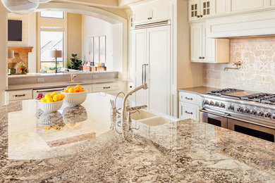 Enclosed kitchen - large traditional l-shaped enclosed kitchen idea in Houston with a double-bowl sink, beaded inset cabinets, white cabinets, granite countertops, beige backsplash, mosaic tile backsplash, stainless steel appliances and an island