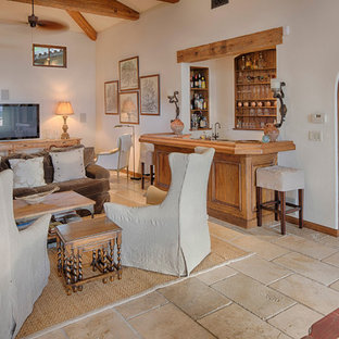 Imagen de salón con barra de bar abierto, mediterráneo, de tamaño medio, sin televisor, con paredes blancas, suelo de madera en tonos medios y chimenea tradicional