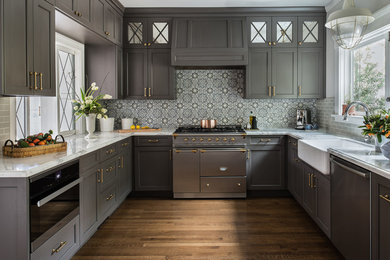 Transitional u-shaped medium tone wood floor kitchen photo in San Francisco with a farmhouse sink, shaker cabinets, gray cabinets, multicolored backsplash, stainless steel appliances, no island and multicolored countertops