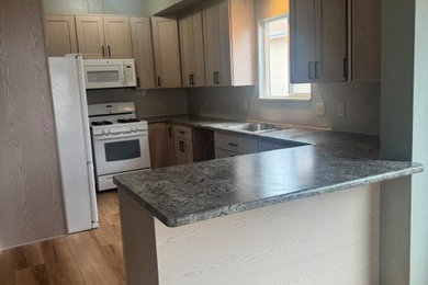 Inspiration for a small timeless galley light wood floor and brown floor enclosed kitchen remodel in Denver with raised-panel cabinets, light wood cabinets, laminate countertops, gray backsplash, ceramic backsplash, white appliances, a peninsula and gray countertops