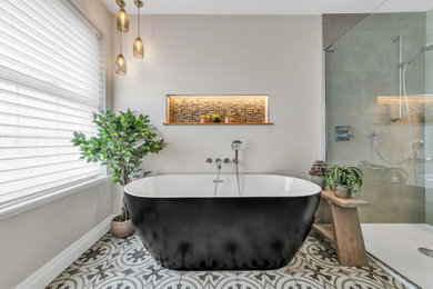 Photo of a medium sized bathroom in Sussex with shaker cabinets, purple cabinets, a freestanding bath, multi-coloured tiles, porcelain flooring, marble worktops, a hinged door, white worktops, double sinks and a freestanding vanity unit.