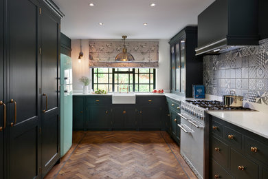 Design ideas for a mid-sized transitional u-shaped separate kitchen in Essex with a farmhouse sink, green cabinets, quartz benchtops, grey splashback, ceramic splashback, white appliances, no island, flat-panel cabinets, dark hardwood floors and white benchtop.