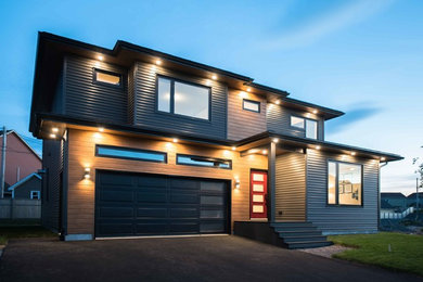 Example of a large minimalist gray two-story mixed siding house exterior design in Other with a hip roof and a shingle roof