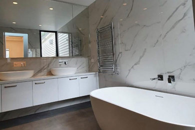 Inspiration for a mid-sized modern bathroom in Melbourne with furniture-like cabinets, white cabinets, a freestanding tub, multi-coloured tile, marble, cement tiles, marble benchtops, grey floor, white benchtops, a double vanity and a floating vanity.