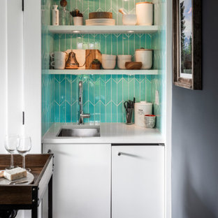 シアトルの小さいコンテンポラリースタイルのおしゃれなバーカート (アンダーカウンターシンク、フラットパネル扉のキャビネット、白いキャビネット、人工大理石カウンター、青いキッチンパネル、セラミックタイルのキッチンパネル、コルクフローリング、茶色い床、白いキッチンカウンター) の写真