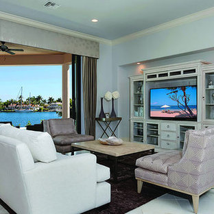Photo of a medium sized mediterranean open plan living room in Miami with blue walls, travertine flooring, no fireplace and a freestanding tv.