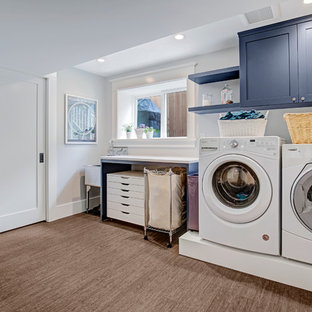 Inspiration for a medium sized traditional single-wall utility room in Seattle with an utility sink, flat-panel cabinets, blue cabinets, engineered stone countertops, grey walls, a side by side washer and dryer, brown floors, white worktops and bamboo flooring.