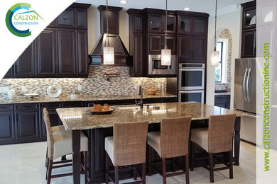 Inspiration for a timeless kitchen remodel in Tampa with a double-bowl sink, raised-panel cabinets, brown cabinets, granite countertops, beige backsplash, glass tile backsplash, stainless steel appliances and an island