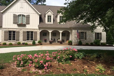 Example of a large classic beige two-story mixed siding exterior home design in Other with a shingle roof