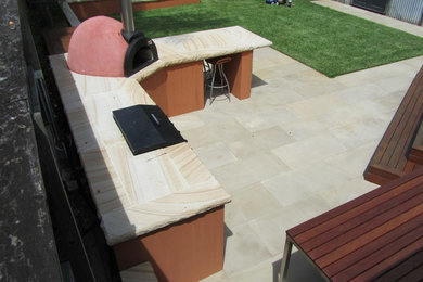 Country backyard full sun garden in Sydney with natural stone pavers.