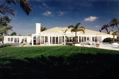 Imagen de fachada de casa blanca marinera grande de una planta con revestimiento de estuco y tejado a cuatro aguas