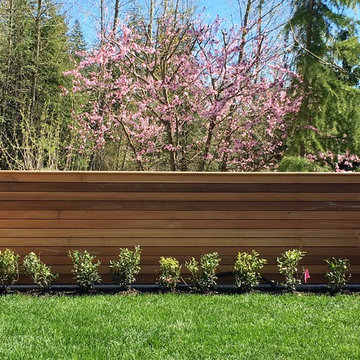 Detail: cedar fence in foreground anchored by lawn