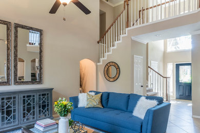 Large transitional open concept porcelain tile family room photo in Houston with beige walls, a standard fireplace, a stone fireplace and no tv