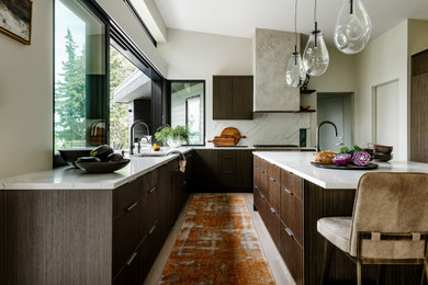 This is an example of a mid-sized modern kitchen in Seattle with flat-panel cabinets, dark wood cabinets, granite benchtops, marble splashback, panelled appliances, with island and white benchtop.