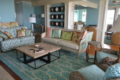 This is an example of a beach style living room in Other with blue walls and medium hardwood floors.