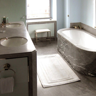Mid-sized transitional master gray tile and stone slab marble floor alcove shower photo in New York with an undermount sink, glass-front cabinets, gray cabinets, granite countertops, an undermount tub and blue walls
