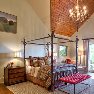 Idee per una grande camera matrimoniale stile rurale con pareti beige e pavimento in legno massello medio
