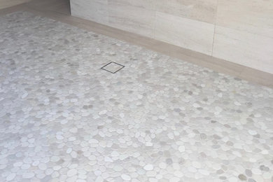 Huge minimalist master beige tile and limestone tile pebble tile floor doorless shower photo in Los Angeles