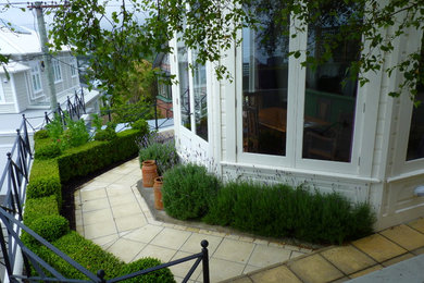 Photo of a contemporary front yard formal garden in Wellington with concrete pavers.