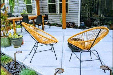 Diseño de patio minimalista de tamaño medio en patio trasero con losas de hormigón