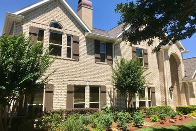 Example of a classic beige two-story exterior home design in Houston with a shingle roof