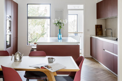 Design ideas for a medium sized modern open plan kitchen in Other with glass-front cabinets, red cabinets, composite countertops, white splashback, ceramic splashback and white worktops.