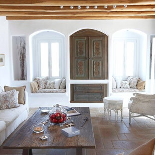 Imagen de salón mediterráneo con paredes blancas y televisor retractable