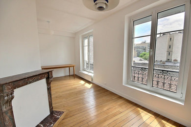 Inspiration pour un salon blanc et bois traditionnel de taille moyenne et ouvert avec un mur blanc, parquet clair et une cheminée d'angle.