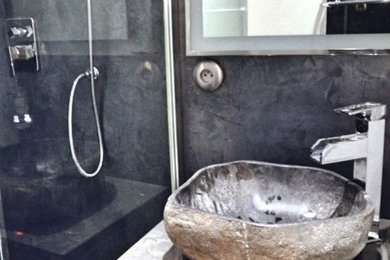 Idée de décoration pour une salle de bain design avec une douche à l'italienne, un mur gris et une vasque.