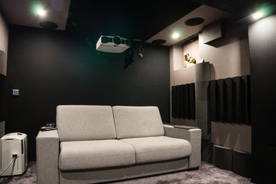 Idées déco pour une petite salle de cinéma moderne fermée avec un mur noir, moquette, un écran de projection et un sol gris.