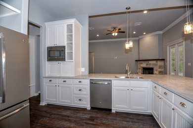 Large trendy l-shaped vinyl floor eat-in kitchen photo in Austin with a drop-in sink, beaded inset cabinets, white cabinets, granite countertops and stainless steel appliances