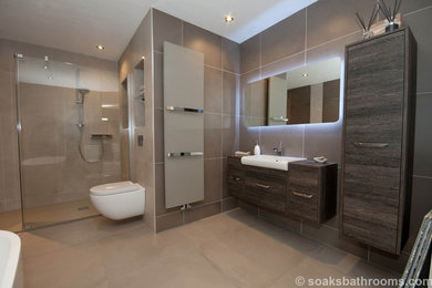 This is an example of a medium sized contemporary family bathroom with flat-panel cabinets, dark wood cabinets, a freestanding bath, an alcove shower, a wall mounted toilet, beige tiles, porcelain tiles, brown walls, porcelain flooring, a console sink and wooden worktops.