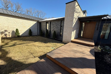 Minimalist black one-story stone exterior home photo in Dallas with a metal roof and a black roof
