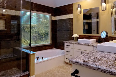 Inspiration for a mid-sized transitional master brown tile and matchstick tile beige floor bathroom remodel in Houston with shaker cabinets, white cabinets, yellow walls, a vessel sink, granite countertops, a hinged shower door and gray countertops