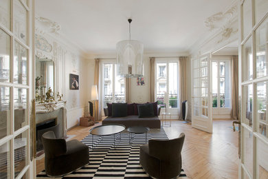 Aménagement d'un salon classique de taille moyenne et ouvert avec un mur blanc, une cheminée standard, un sol marron, parquet clair, un manteau de cheminée en pierre et éclairage.