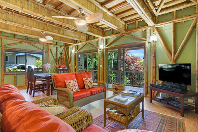 Inspiration for a tropical open concept bamboo floor living room remodel in Hawaii with green walls