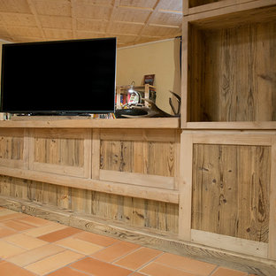 This is an example of a medium sized rustic basement in Venice with terracotta flooring.