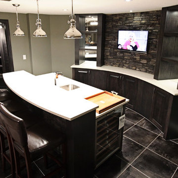 Stone basement wetbar and dark wood cabinetry