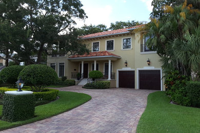 Large black two-story stucco exterior home idea in Tampa with a hip roof