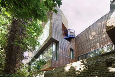 Design ideas for a contemporary house exterior in London with wood cladding.