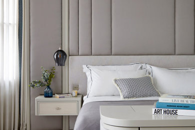 Large transitional master bedroom in London with beige walls, carpet, beige floor and panelled walls.