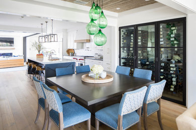 This is an example of a mid-sized country open plan dining in Orange County with white walls, medium hardwood floors and beige floor.