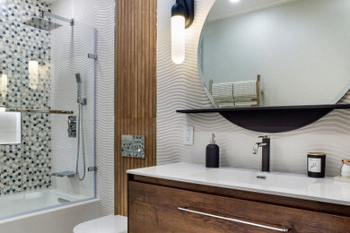 ロサンゼルスにある高級な中くらいなモダンスタイルのおしゃれな浴室 (フラットパネル扉のキャビネット、中間色木目調キャビネット、壁掛け式トイレ、白いタイル、セラミックタイル、白い壁、一体型シンク、人工大理石カウンター、グレーの床、白い洗面カウンター、ニッチ、洗面台1つ、フローティング洗面台、壁紙) の写真