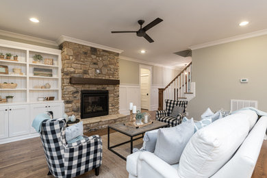 Transitional open concept living room in Raleigh with green walls, dark hardwood floors, a standard fireplace, a stone fireplace surround and brown floor.