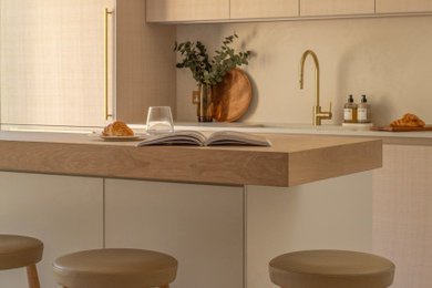 This is an example of a medium sized contemporary galley kitchen in Other with flat-panel cabinets, light wood cabinets, quartz worktops and an island.