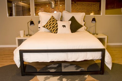 Mid-sized minimalist loft-style light wood floor bedroom photo in Denver with beige walls and no fireplace