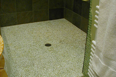 Example of a mid-sized trendy master green tile and slate tile pebble tile floor, white floor and single-sink bathroom design in Other with furniture-like cabinets, light wood cabinets, a wall-mount toilet, green walls, a vessel sink, wood countertops, a niche and a freestanding vanity