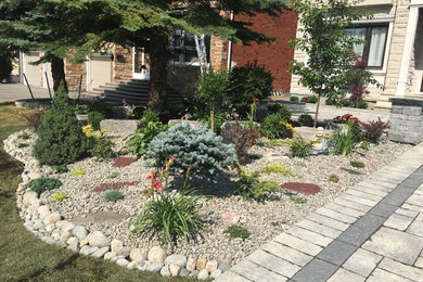 This is an example of a mid-sized transitional front yard brick driveway in Toronto.