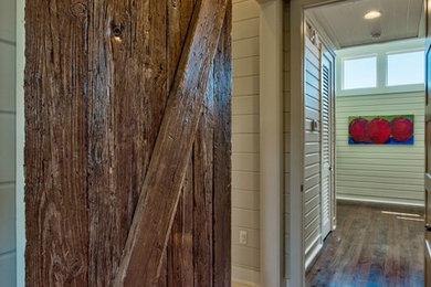 Trendy dark wood floor and brown floor hallway photo in Other with white walls