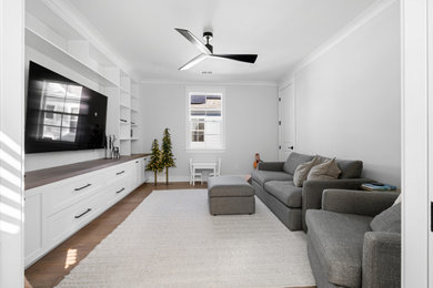 Mid-sized minimalist enclosed vinyl floor and brown floor family room library photo in Charleston with white walls and a wall-mounted tv